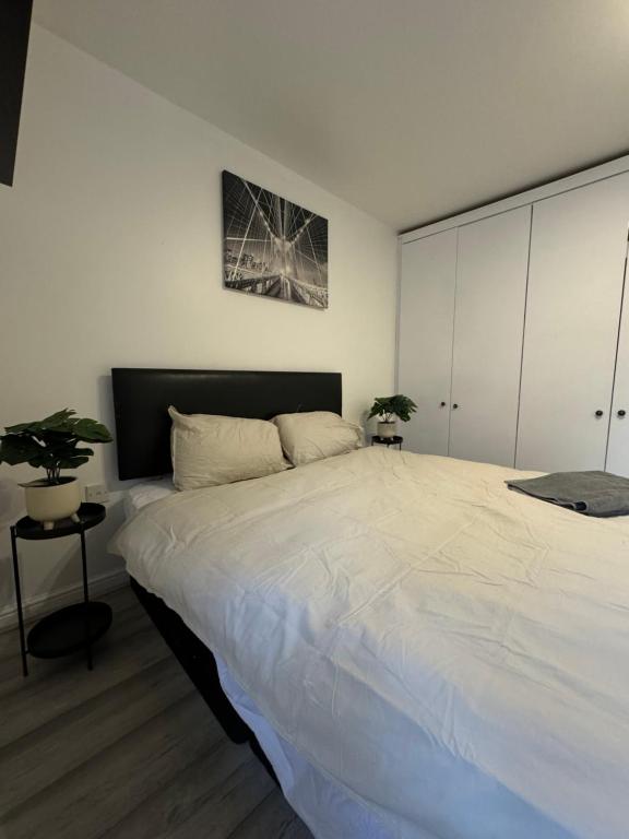 a bedroom with a large white bed in a room at Spacious 3 bedroom Home, with private driveway 5 minutes from Excel Centre & Custom House in London