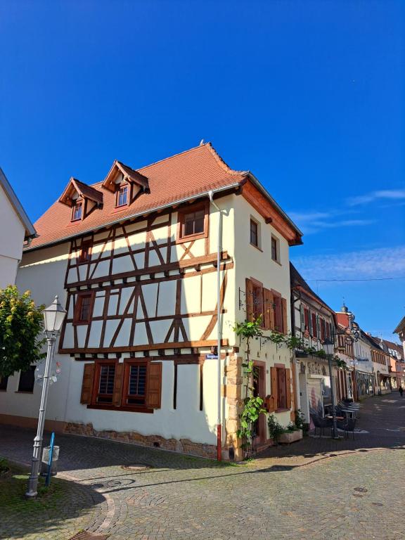 un edificio blanco con techo marrón en una calle en Gästehaus Merlin, en Bad Bergzabern