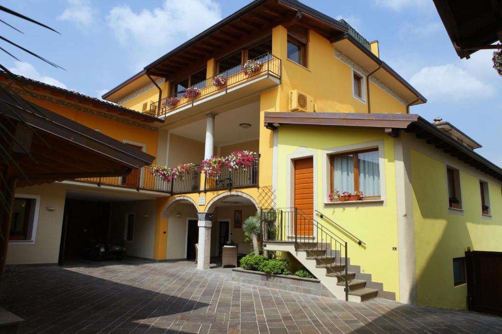 Casa amarilla con escaleras y balcón en Agriturismo Il Barone, en Moniga del Garda