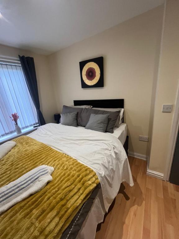 a bedroom with a large bed with a yellow blanket at Shared Room in Ashton under Lyne
