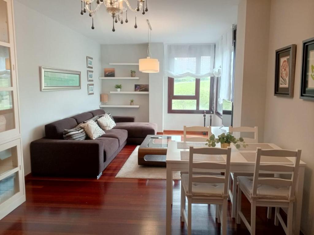 Apartamento Familiar SARDINERO RH 20 في سانتاندير: غرفة معيشة مع أريكة وطاولة