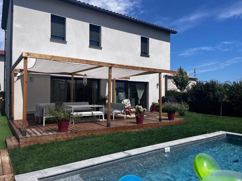 a house with a deck and a swimming pool at Magnifique Villa, Piscine, Proche Plage, 8 personnes in Lansargues