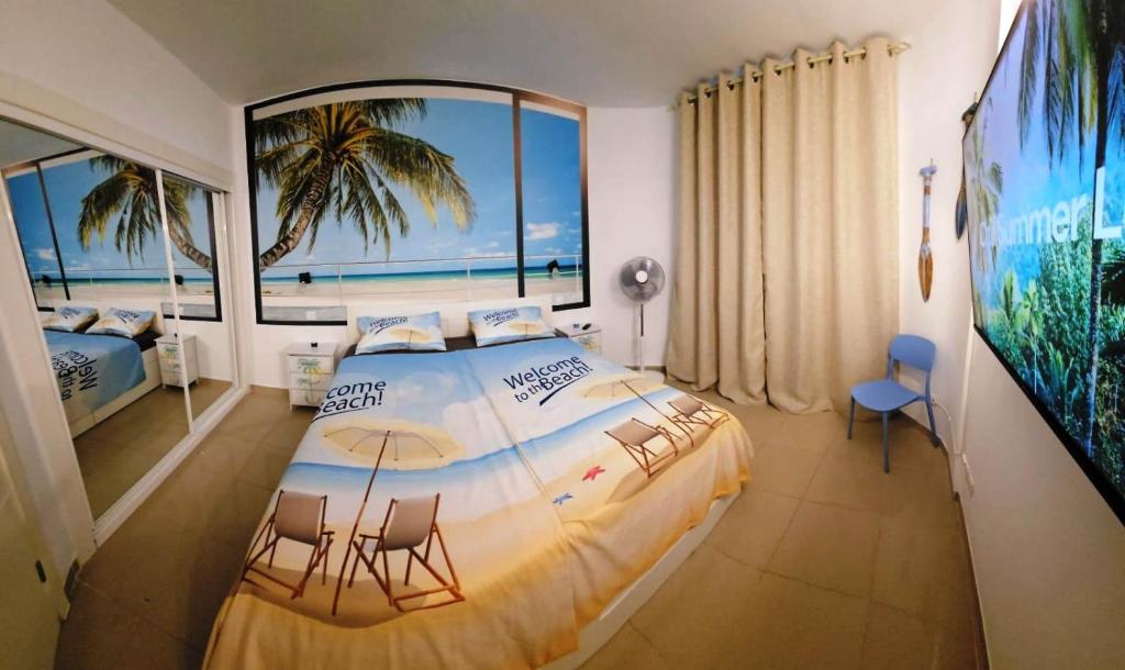 a bedroom with a large bed with a view of the ocean at BLUE BAY PARADISE - Beach front apartment with sea view in Playa Paraiso