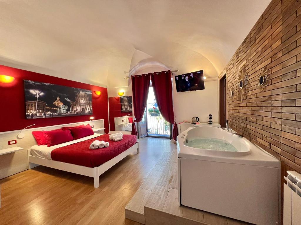Schlafzimmer mit einem Bett und einer Badewanne in der Unterkunft CANTU' SUITE in Catania