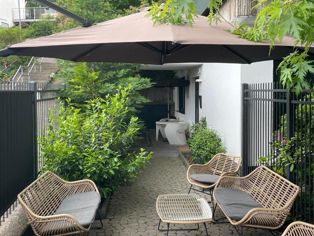 a group of chairs and an umbrella on a patio at the birdy mountains luxury lodge in Schlitz