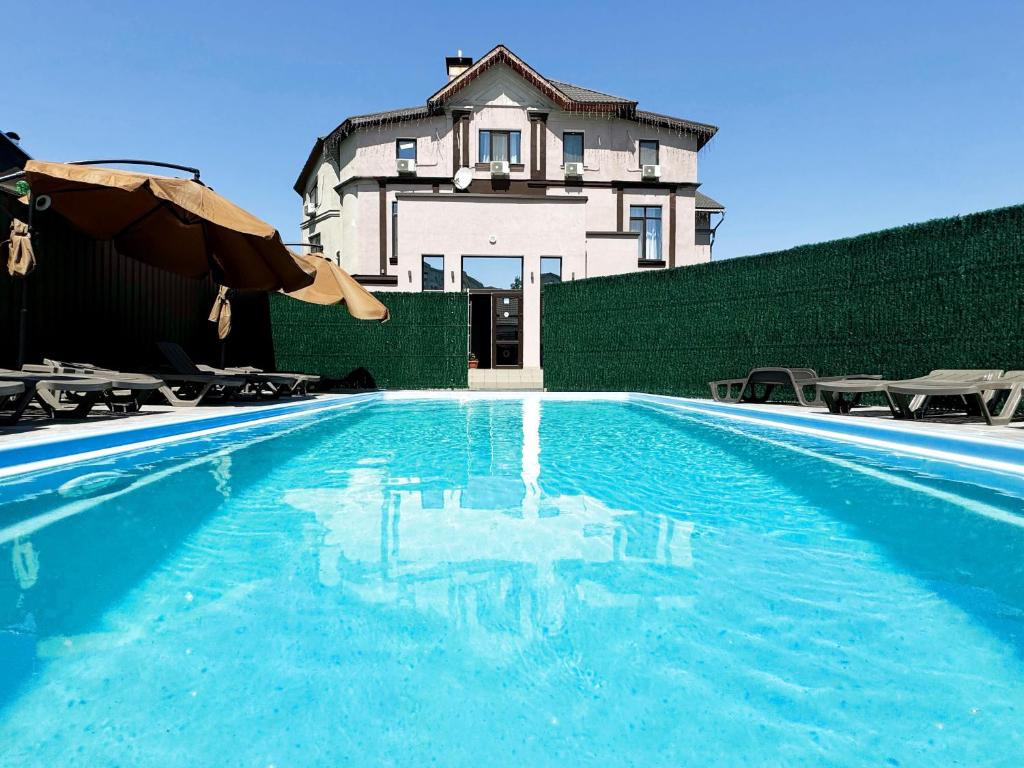ein Haus mit einem Pool vor einem Gebäude in der Unterkunft SIGNEEV'S Villa in Kiew