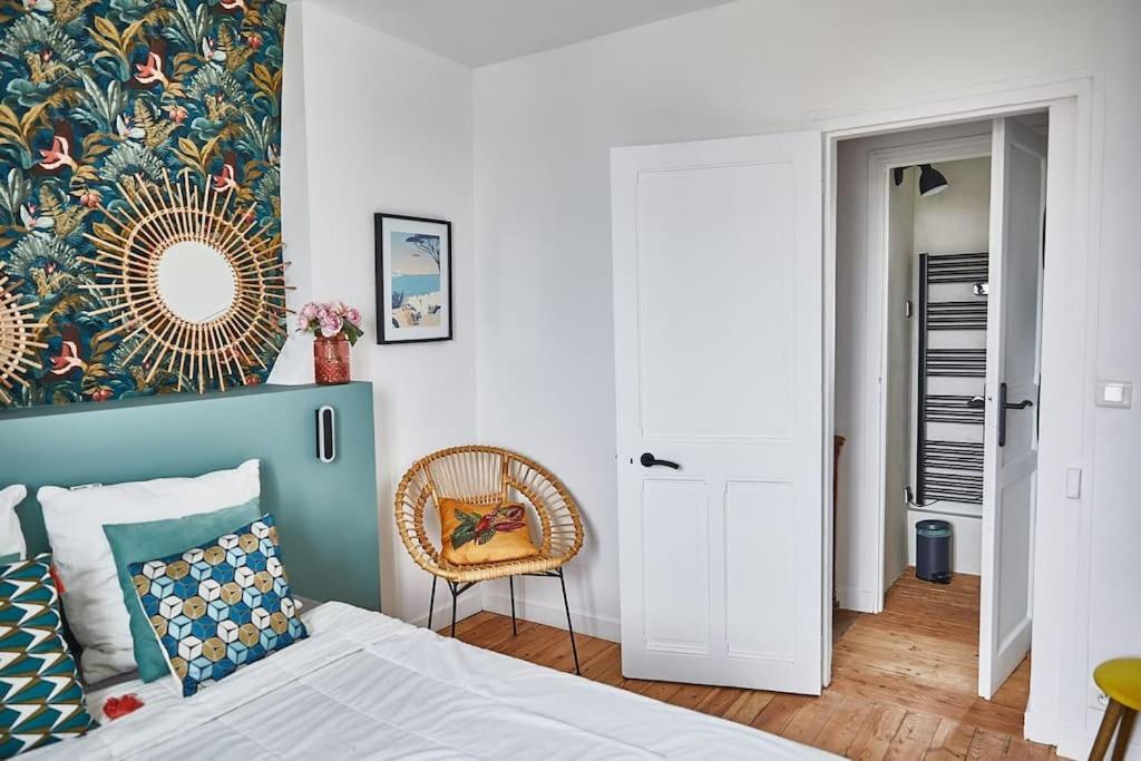 une chambre avec un lit, un miroir et une chaise dans l'établissement Charmante maison de bord de mer, à Houlgate