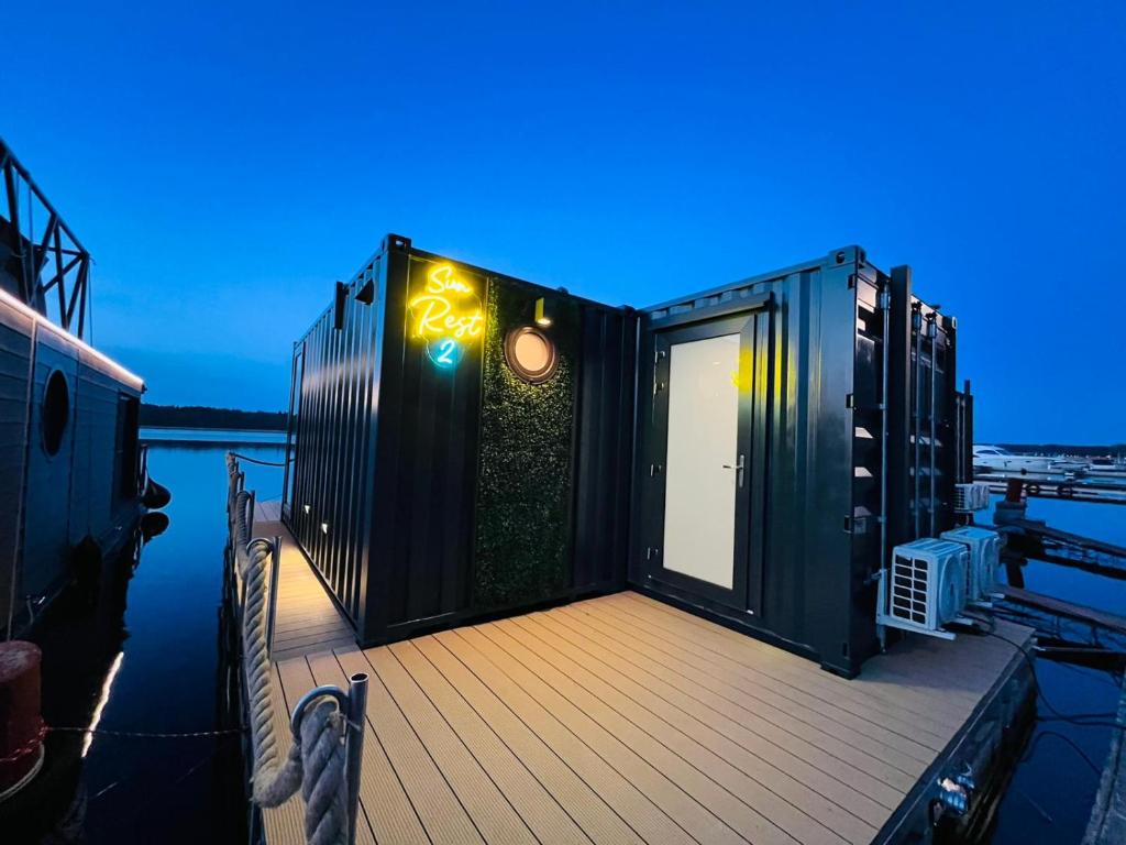 a cabin on a boat on the water at night at Apartament na wodzie Augustów in Augustów