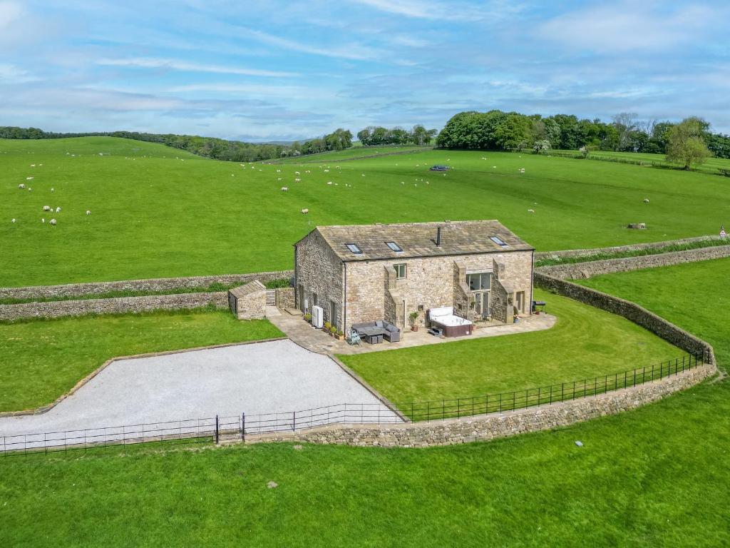 an aerial view of a stone building in a field at Crane Field Laithe in Airton