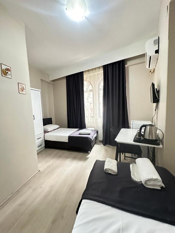 Habitación de hotel con 2 camas y escritorio en GLR OTEL, en Balıkesir