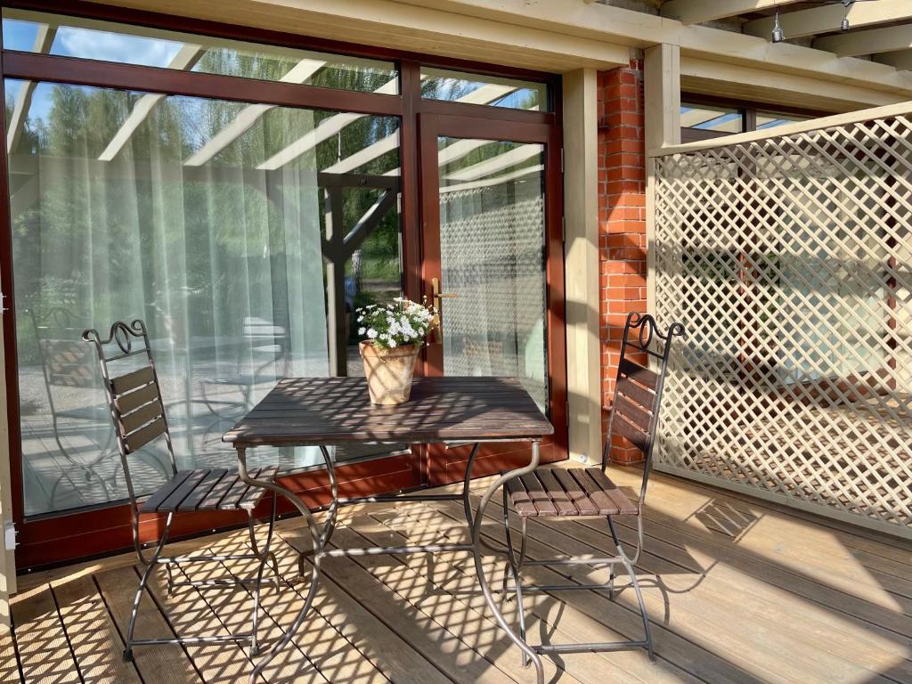 a table and two chairs on a screened porch at Karlamuiza Country Hotel in Kārļi