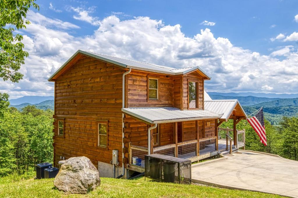a log cabin with a flag in front of it at Freedoms View, Game Room & Amazing Views, FREE tickets each paid day, Hot Tub!!! in Sevierville