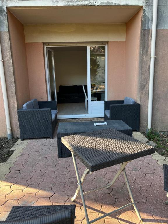 une table et des chaises devant un bâtiment dans l'établissement Appartement avec place de parking privé et jardin, à Beaumont-sur-Oise