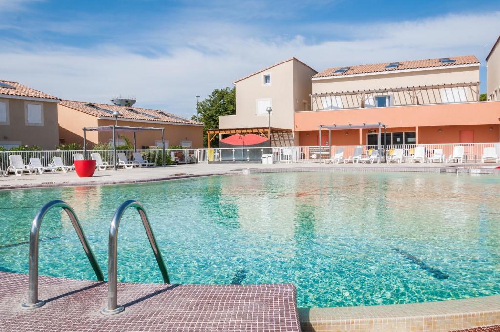 einem großen Pool vor einem Gebäude in der Unterkunft Vacancéole - Les Demeures Torrellanes - Saint-Cyprien in Saint-Cyprien