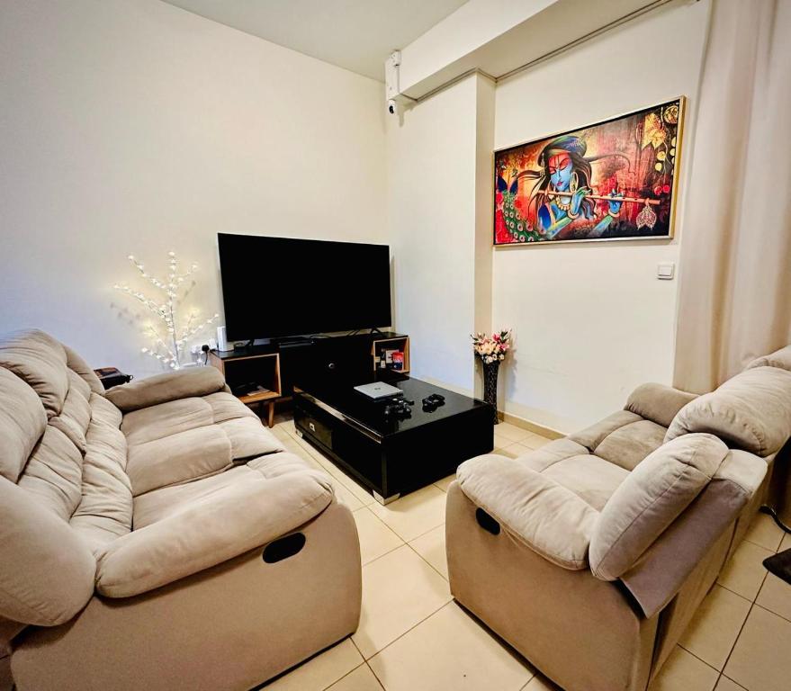 - un salon avec deux canapés et une télévision à écran plat dans l'établissement The Aero Vacation Homes, à Dubaï