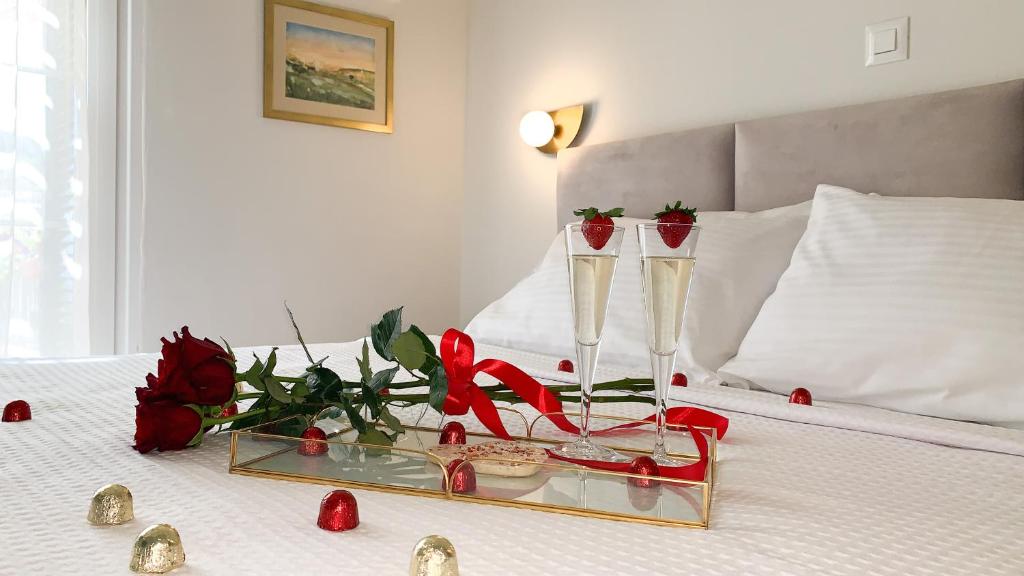 a bed with two champagne glasses and roses on it at Rouchotas Apartments in Argostoli