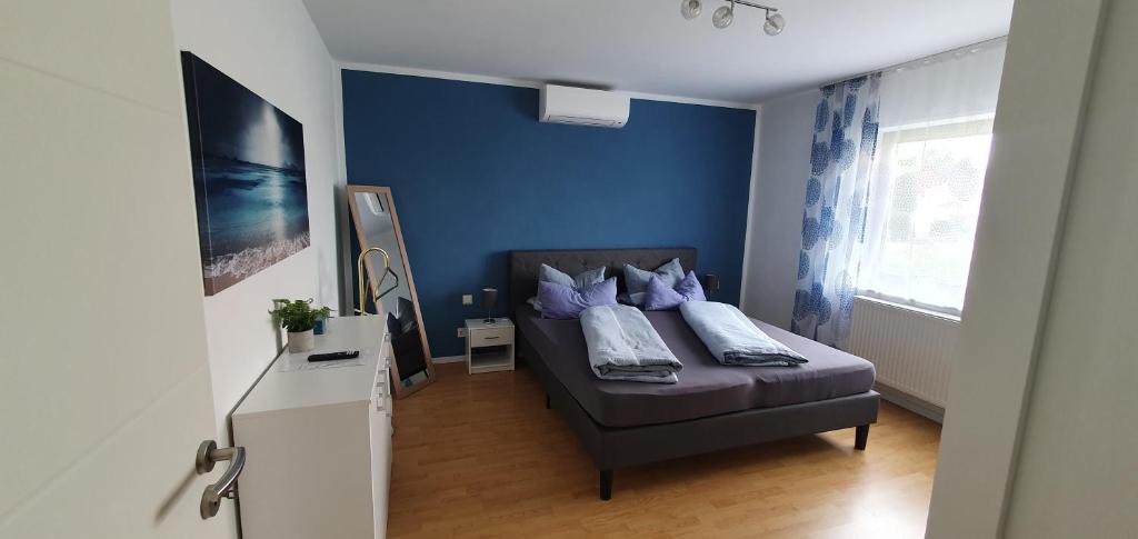 1 dormitorio con 1 cama con pared azul en 4****Sterne Ferienwohnung Mia DTV Klassifizierung en Blieskastel