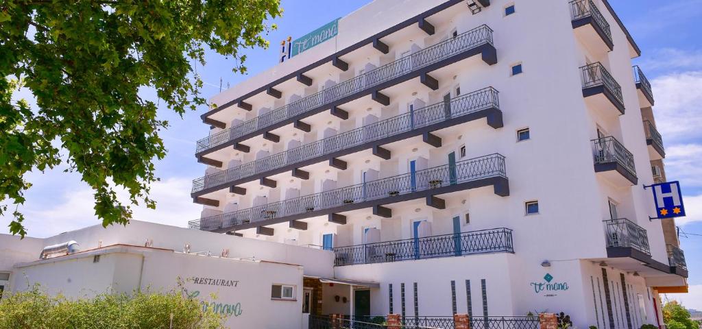 Te Maná Hotel في توريبلانكا: مبنى ابيض كبير عليه بلكونات