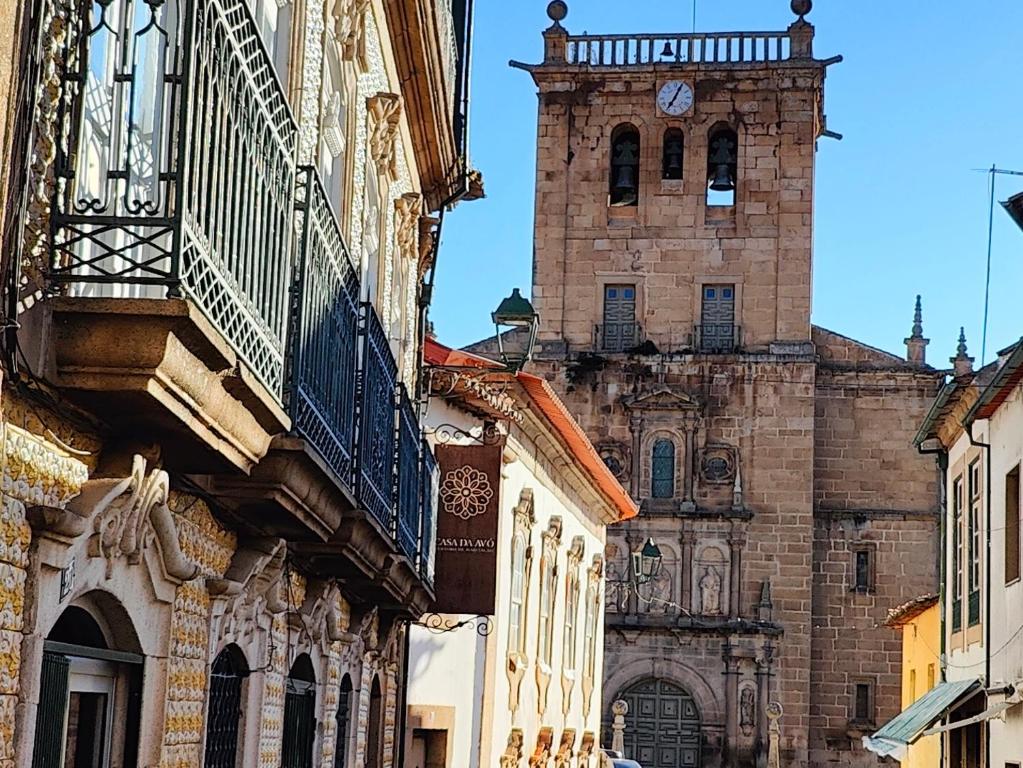 an old building with a clock tower in a city at Casa Da Avo - Turismo De Habitacao in Torre de Moncorvo