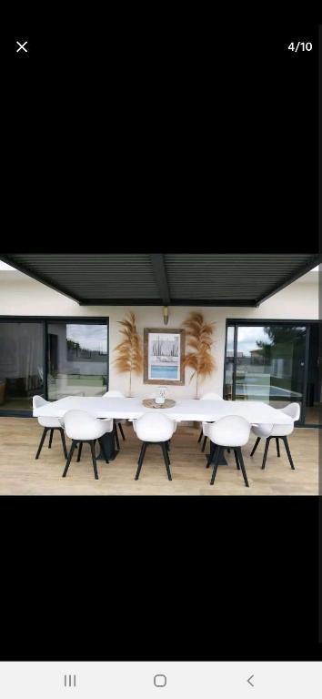 un groupe de tables et de chaises dans une pièce dans l'établissement Villa avec piscine, à Alès