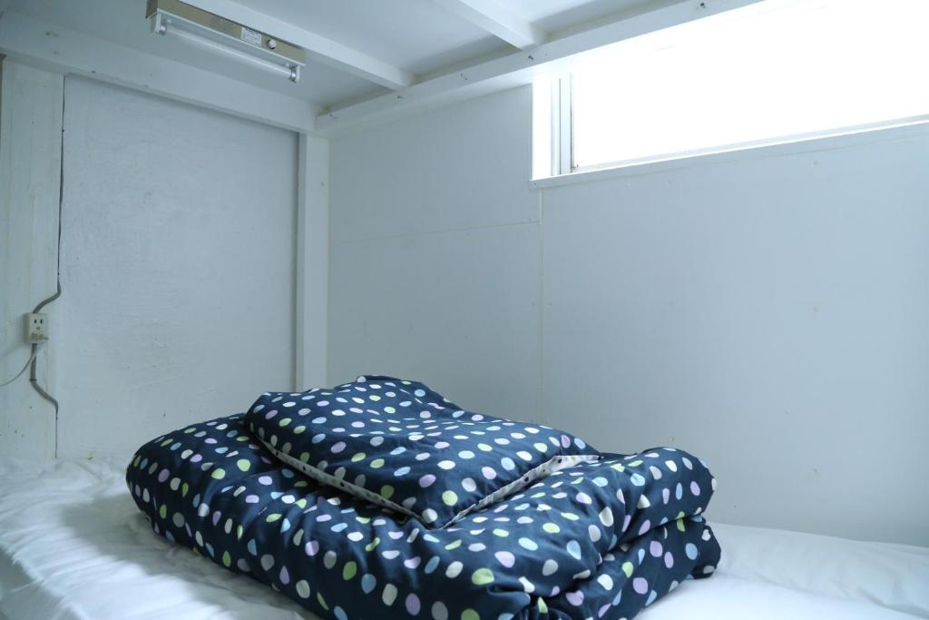 a couple of pillows sitting on top of a bed at Little Asia Guest House in Naha