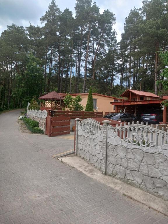 einen weißen Zaun vor einem Gebäude in der Unterkunft Betlejem Domek nad Jeziorem in Gostyczyn