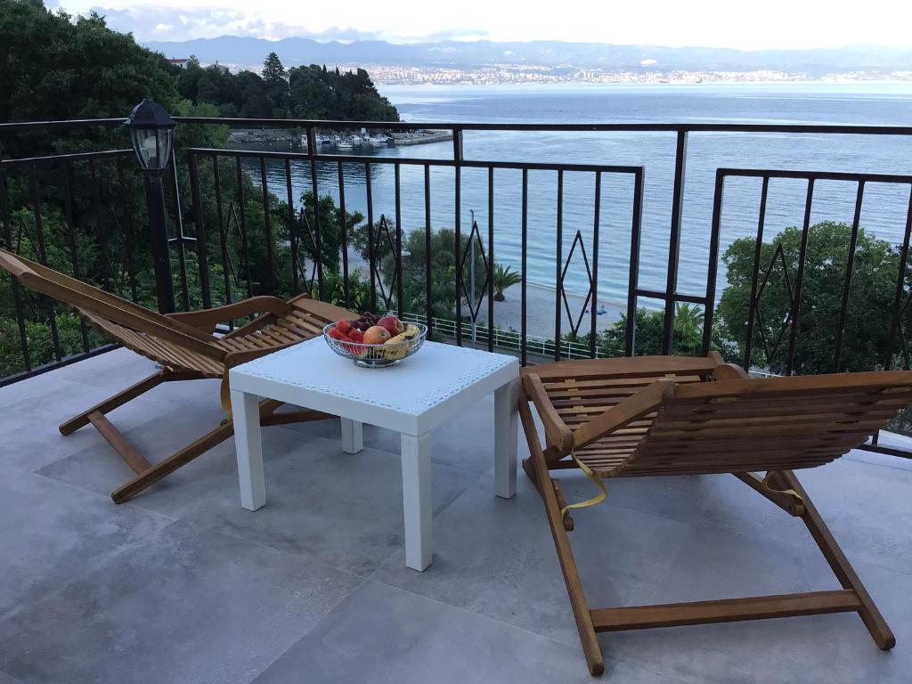 una mesa y 2 sillas y un bol de fruta en el balcón en House Vali en Lovran