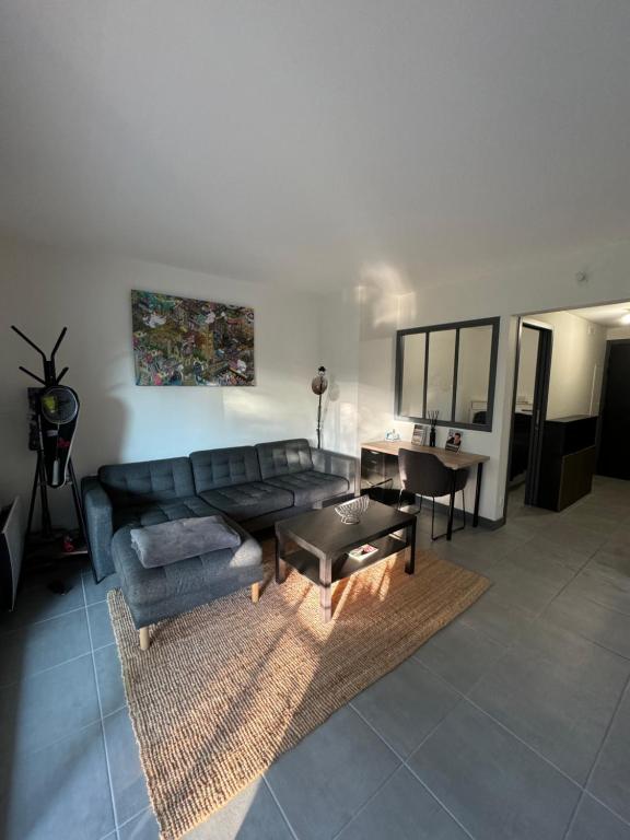 un salon avec un canapé noir et une table dans l'établissement Très bel appartement, à Cannes