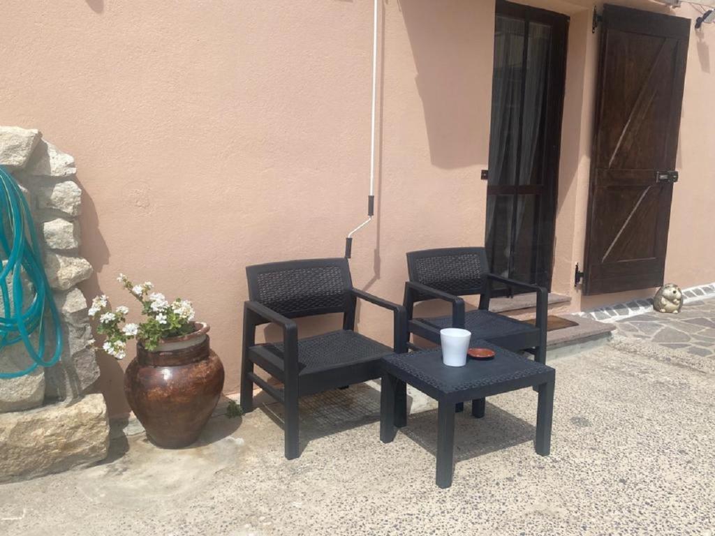 2 chaises et une table en face d'un bâtiment dans l'établissement Casetta Vacanze Nonna Antonietta, à Carbonia