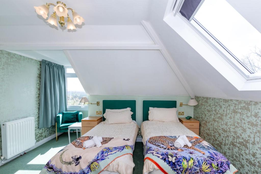 1 dormitorio con 2 camas en un ático en Phoenix Rise Retreat en Glastonbury