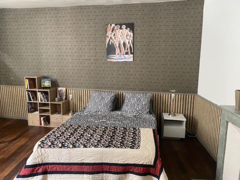 une chambre avec un lit et un tableau au mur dans l'établissement Appartement centre St-Mihiel, à Saint-Mihiel