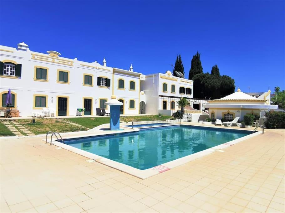 a large house with a swimming pool in front of it at Casa Tulipa Ferias - Vilamoura in Quarteira
