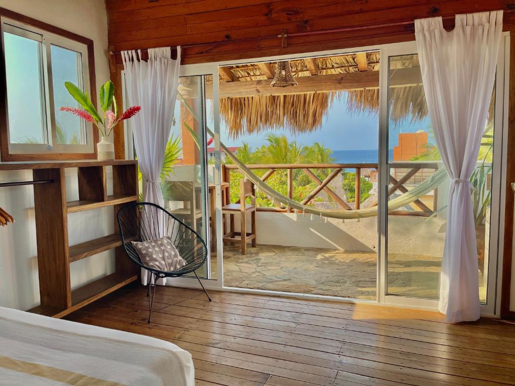 a bedroom with a bed and a view of the ocean at Hotel Casa Mixteca in Zipolite