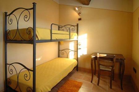 カスティリオーネ・デル・ラーゴにあるPoggio Milleのベッドルーム1室(二段ベッド1組、テーブル、椅子付)