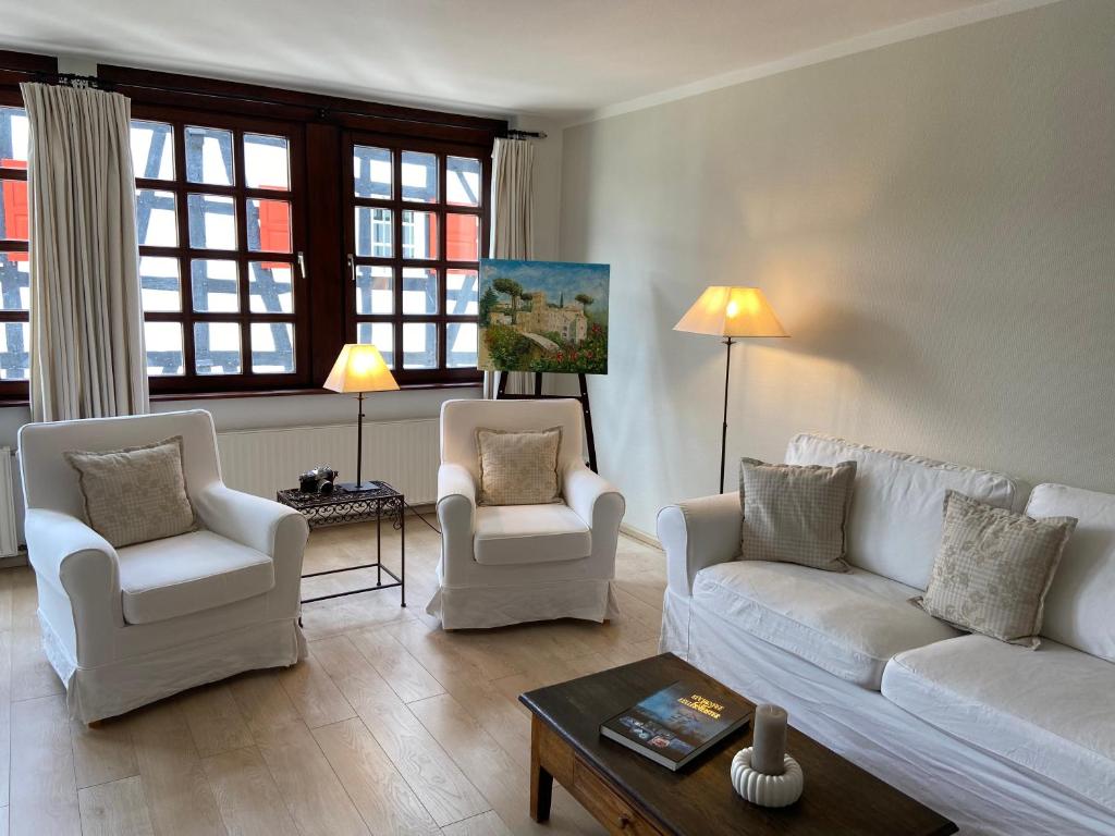 a living room with two white couches and two chairs at Haus Dürresbach in Hennef