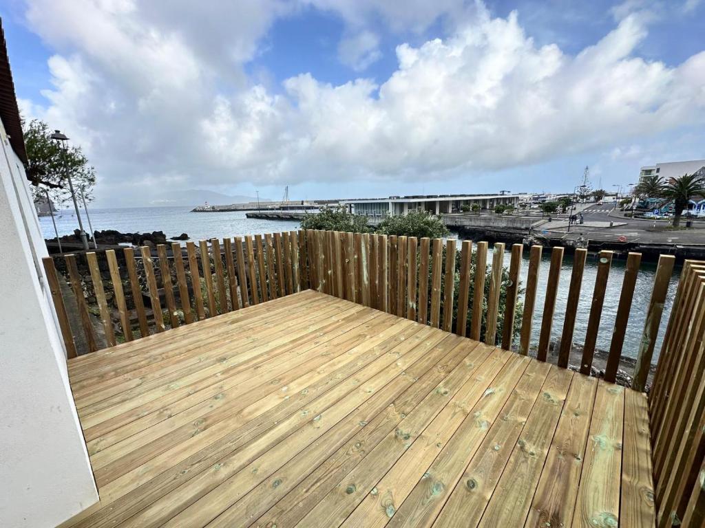 a wooden deck with a fence next to the ocean at T0 com mezanino à beira-mar in Madalena