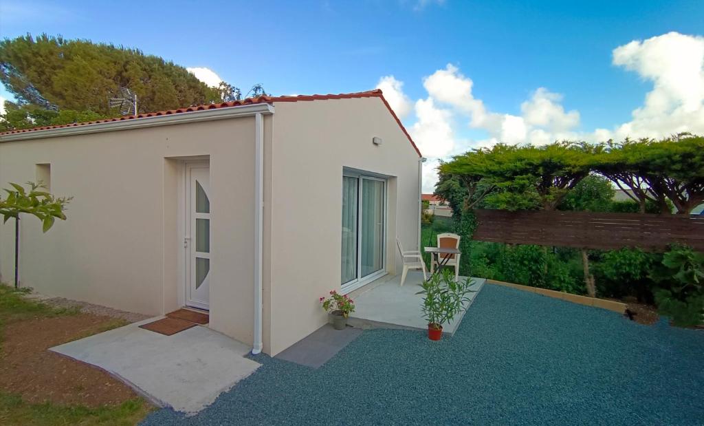 - un petit bâtiment blanc avec une table et une chaise dans l'établissement Maisonnette indépendante, à Montroy