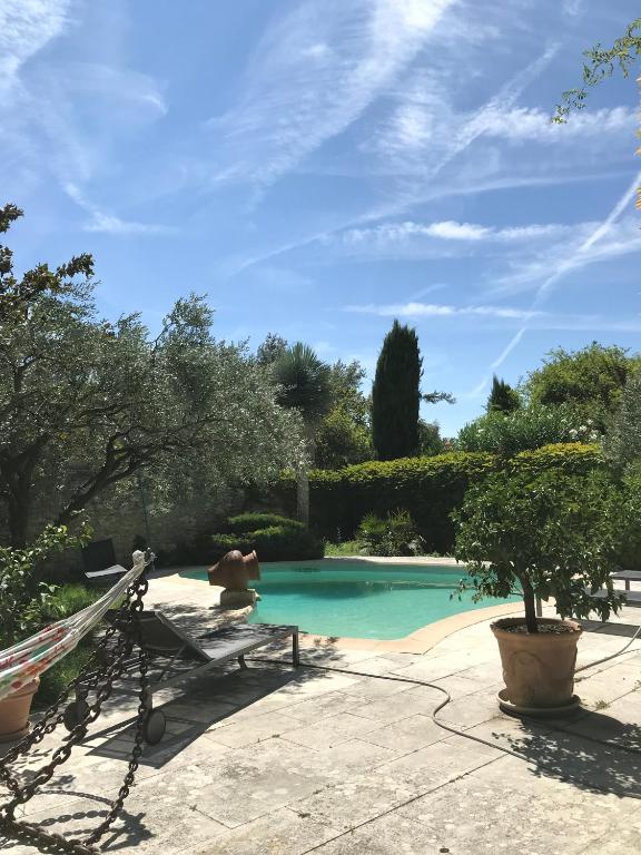 une piscine avec un banc et un arbre dans l'établissement Thebertisa, à Valréas