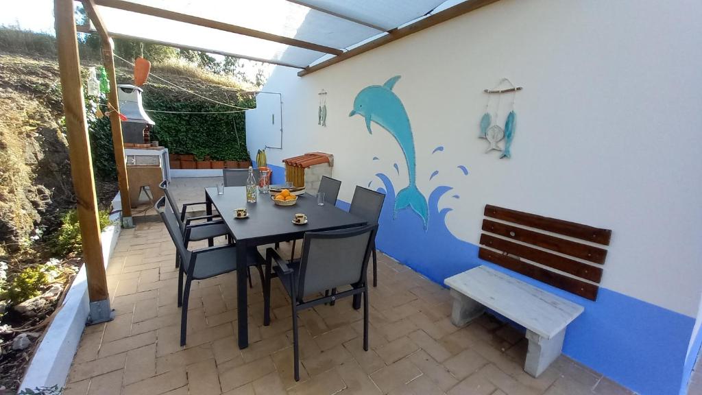 a dining room with a table and chairs on a patio at Charme Rústico in Aljezur