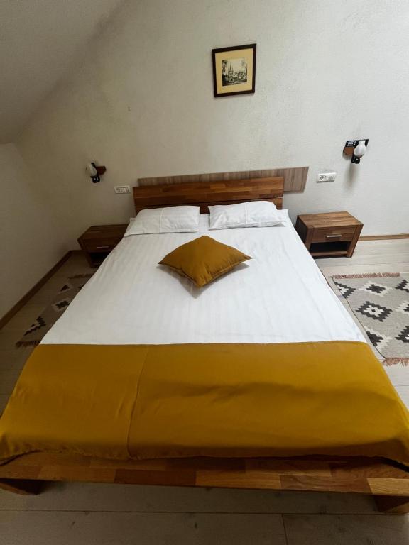 Cozy Apartment في براشوف: غرفة نوم بسرير كبير مع بطانية صفراء