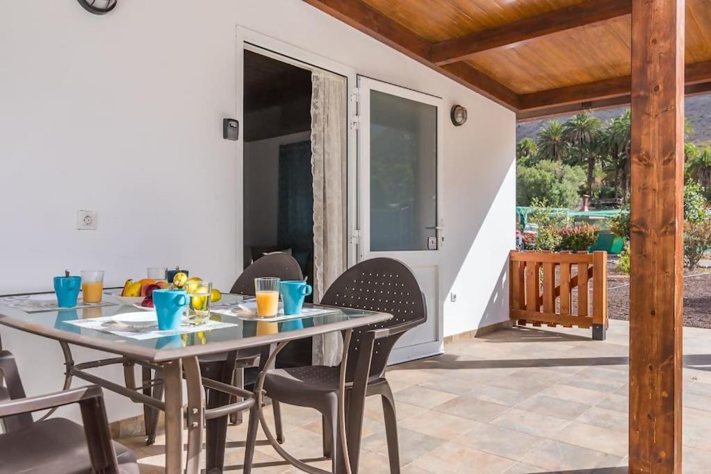ein Esszimmer mit einem Tisch und Stühlen auf einer Terrasse in der Unterkunft Country House Near Fataga y Maspalomas in Maspalomas