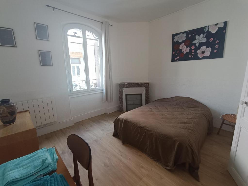 une chambre avec un lit, une fenêtre et une table dans l'établissement Le romalie, à Vichy