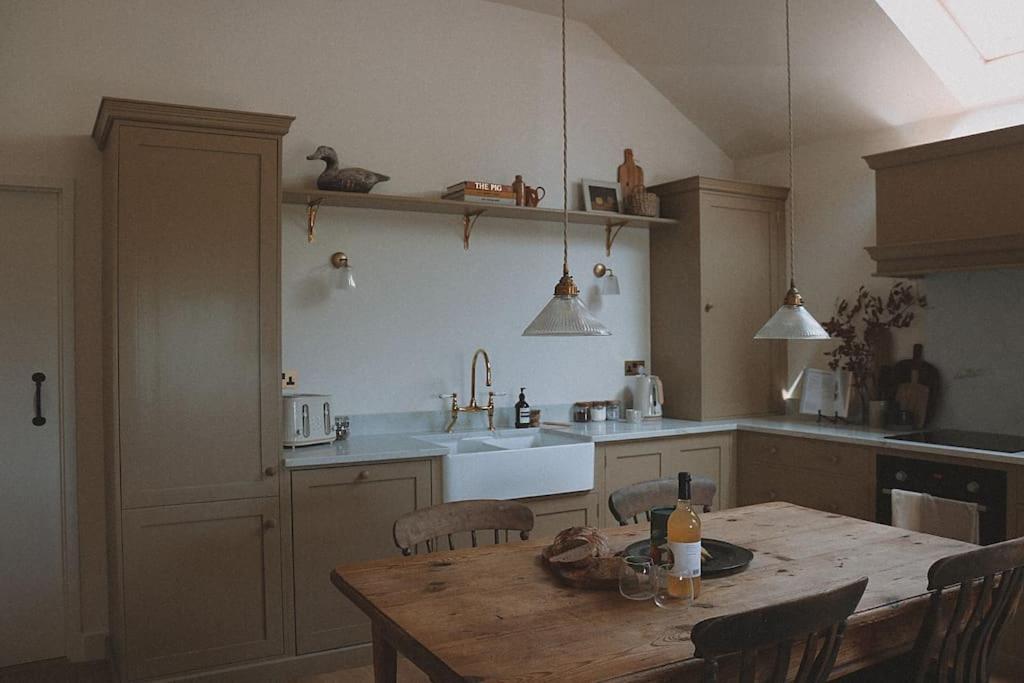 a kitchen with a wooden table with chairs and a tableablish at Stock Barn in Youlgreave