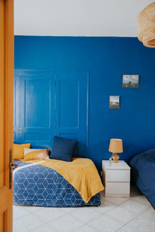 - une chambre bleue dotée d'un lit avec un mur bleu dans l'établissement Maison La Pomaré, à Villeneuve-les-Genêts