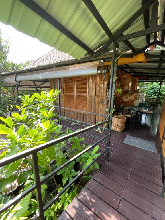 eine Terrasse mit einer Pergola und einigen Pflanzen in der Unterkunft Casa Bonita Kanchanaburi in Kanchanaburi