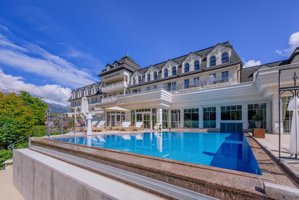 einen Blick auf ein Herrenhaus mit einem Pool in der Unterkunft Grandhotel Lienz Business-Wellness & Gourmet in Lienz