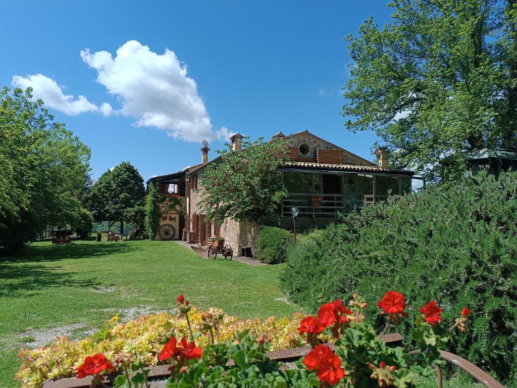 una casa con flores rojas delante de ella en Country House Il Biroccio en Urbino