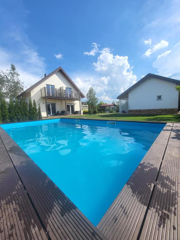 basen z niebieską wodą przed domem w obiekcie Domki Zielona Polana w Rewalu