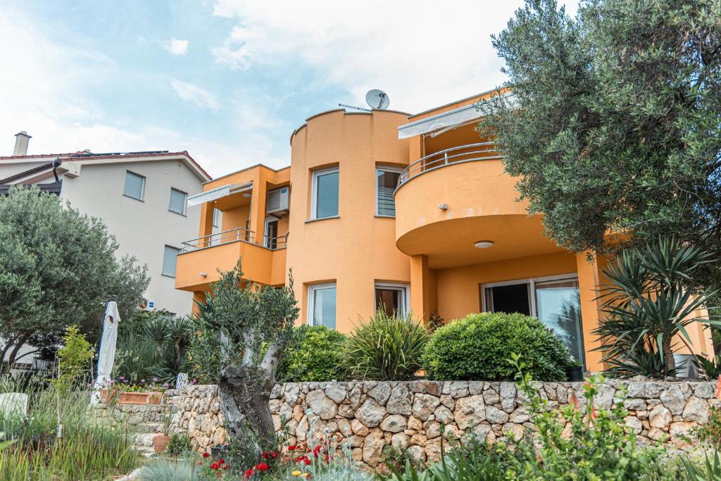 an orange house with a stone wall and trees at Carpe Diem**** in Lun