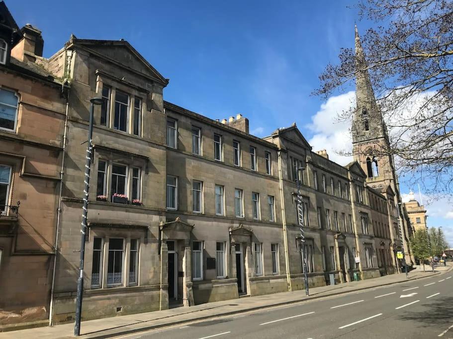 an old building on a street with a tower at Tay View in Perth